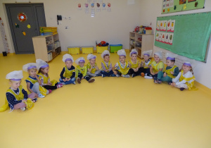 01 Dzieci siedzą w półkolu przebrane w strój kucharza